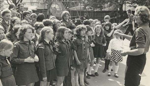 Joan Pover as a leader in Woodcraft Folk in the 1960s, conducting a children's choir