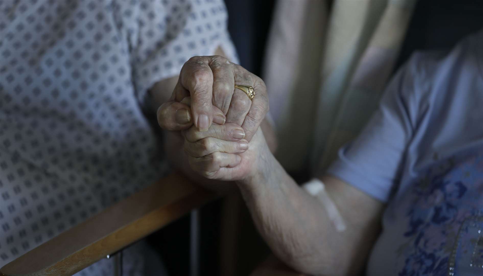 A husband and wife hold hands in a hospital (Kirsty Wigglesworth/PA)