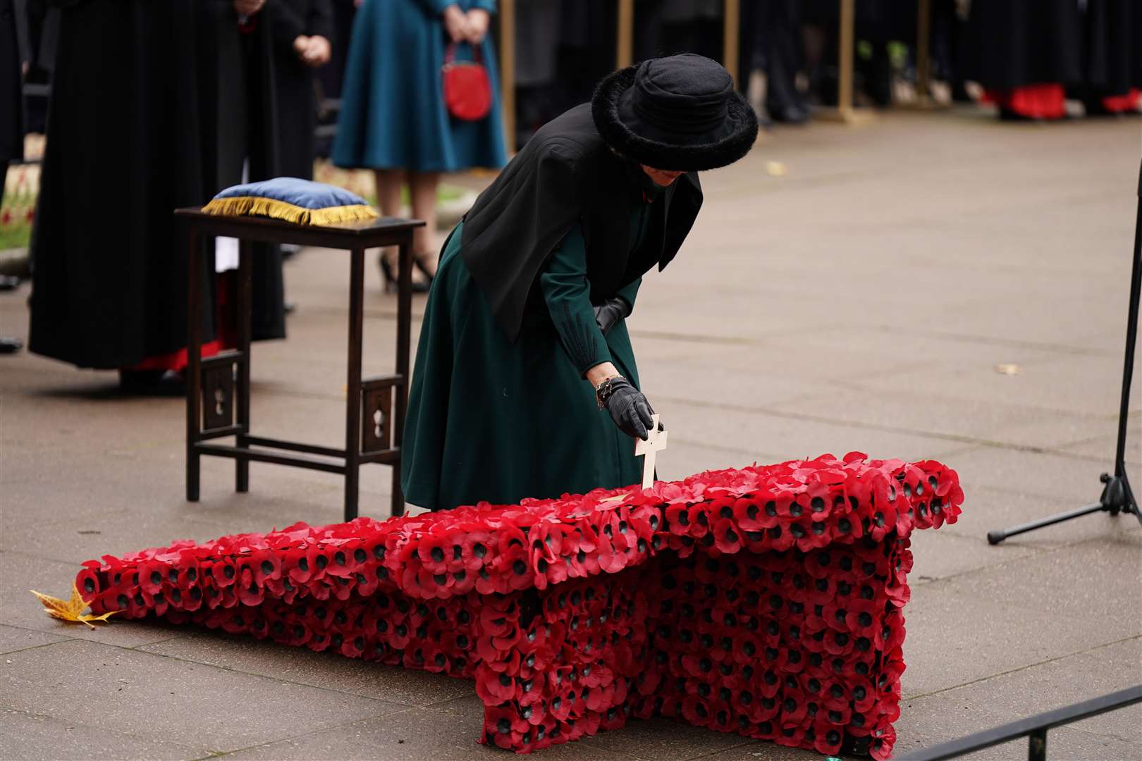 The Queen places a memorial cross during a visit to Westminster Abbey (Aaron Chown/PA)