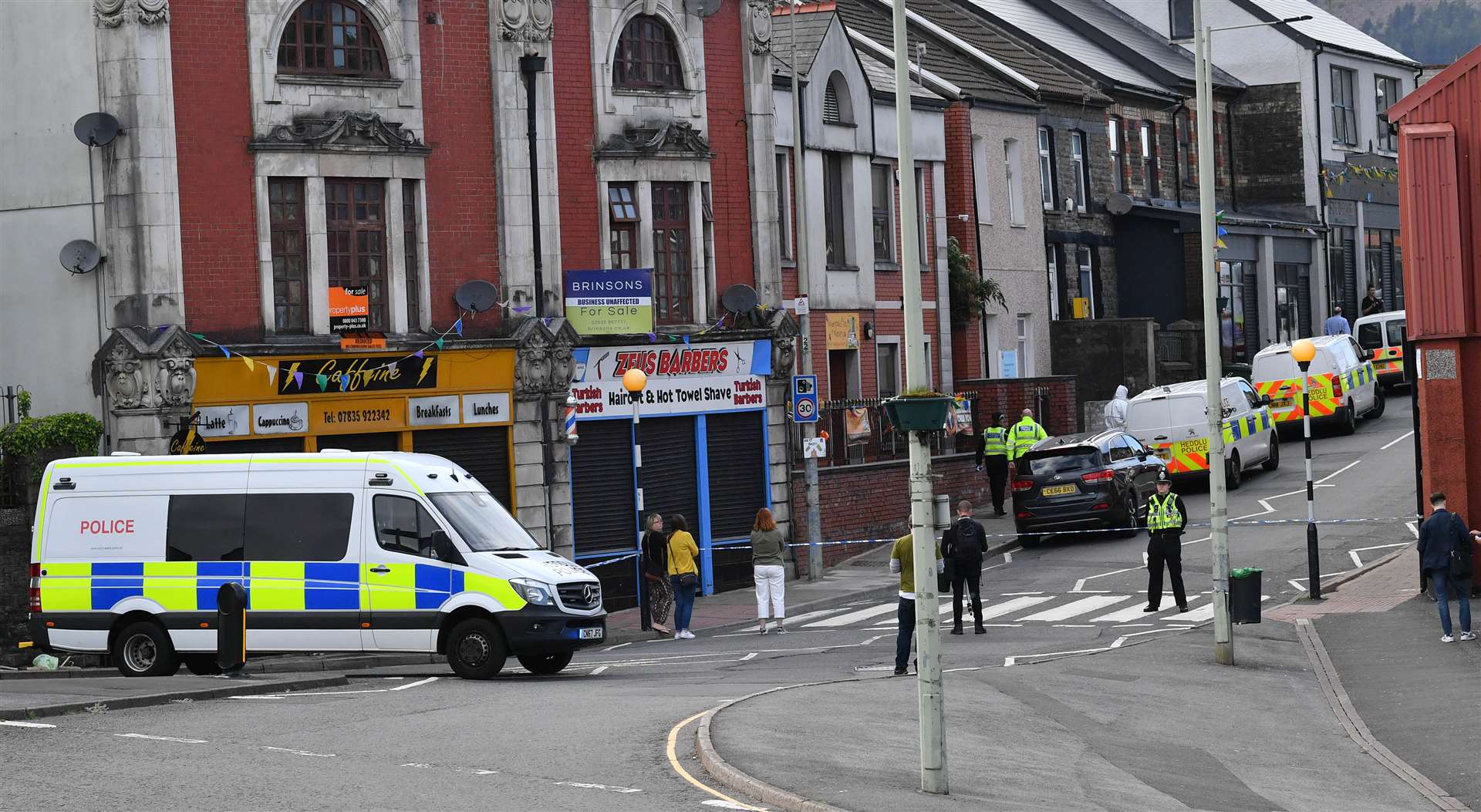 Police at the scene of a reported stabbing in the village of Pen Y Graig (Ben Birchall/PA)