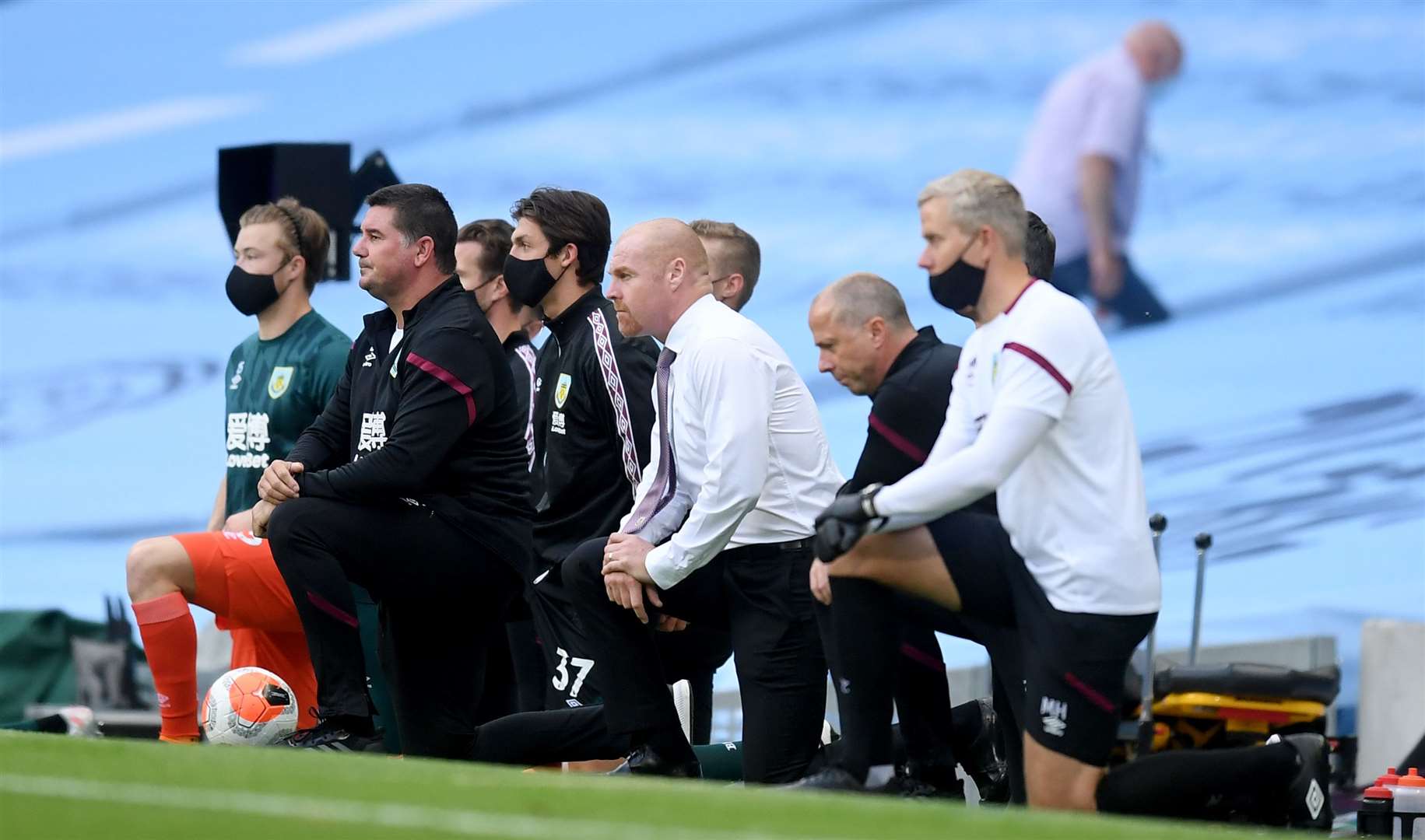 Burnley manager Sean Dyche and his staff take the knee before the Premier League match at Manchester’s Etihad Stadium (Michael Regan/PA)