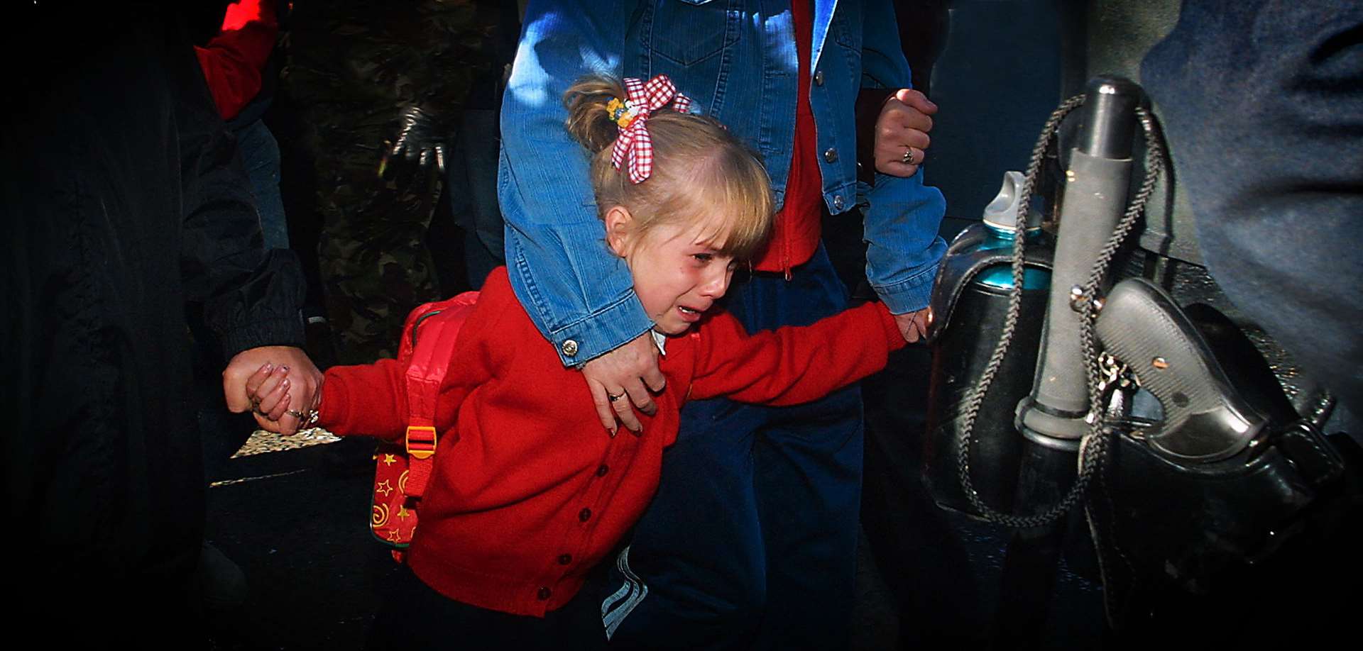 Alice-Lee Bunting clings to her mother as she walks to school in north Belfast in 2001 (Niall Carson/PA)