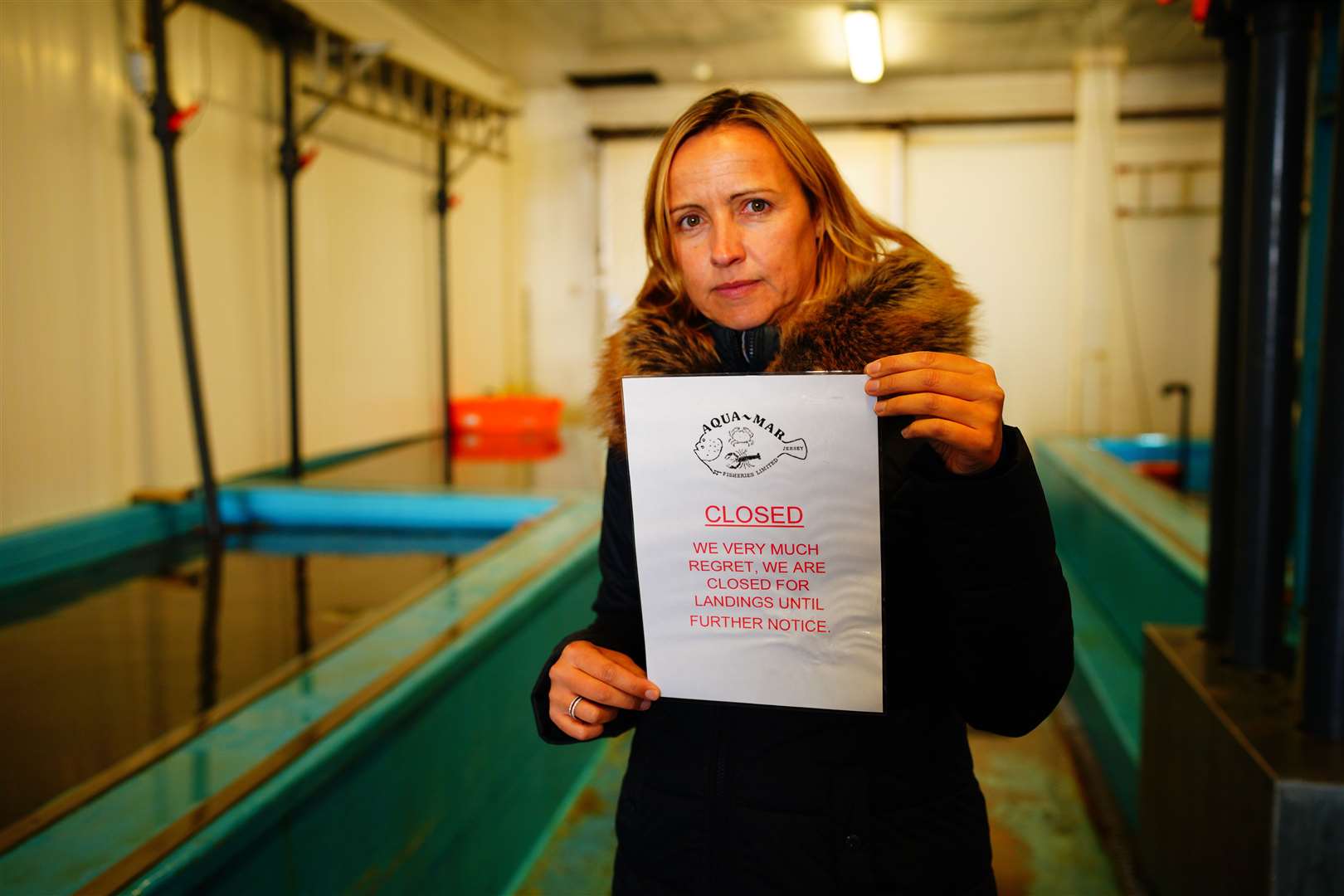 Director of Aqua Mar fisheries in Jersey, Nathalie Porritt, prints a closed sign to let any fishermen know she is winding down trading ahead of political talks (Ben Birchall/PA)