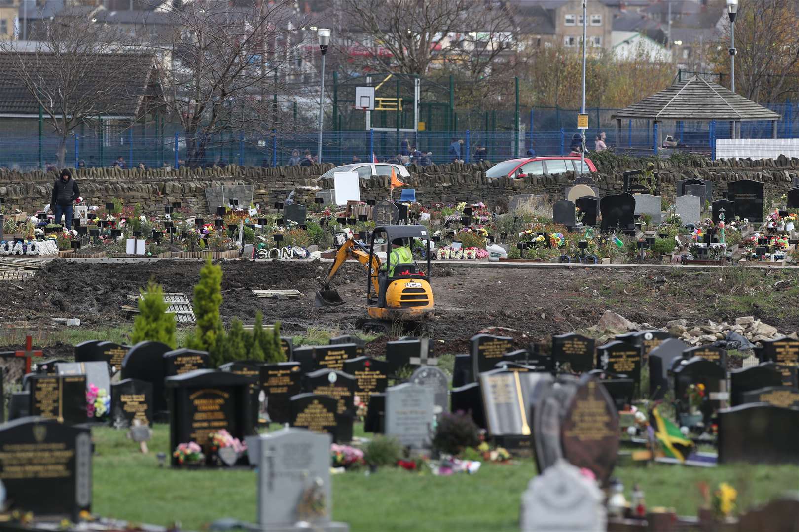 Workers use machinery to dig graves next to the Muslim burial ground at the Scholemoor Cemetery and Crematorium, in Bradford, West Yorkshire (Danny Lawson/PA)