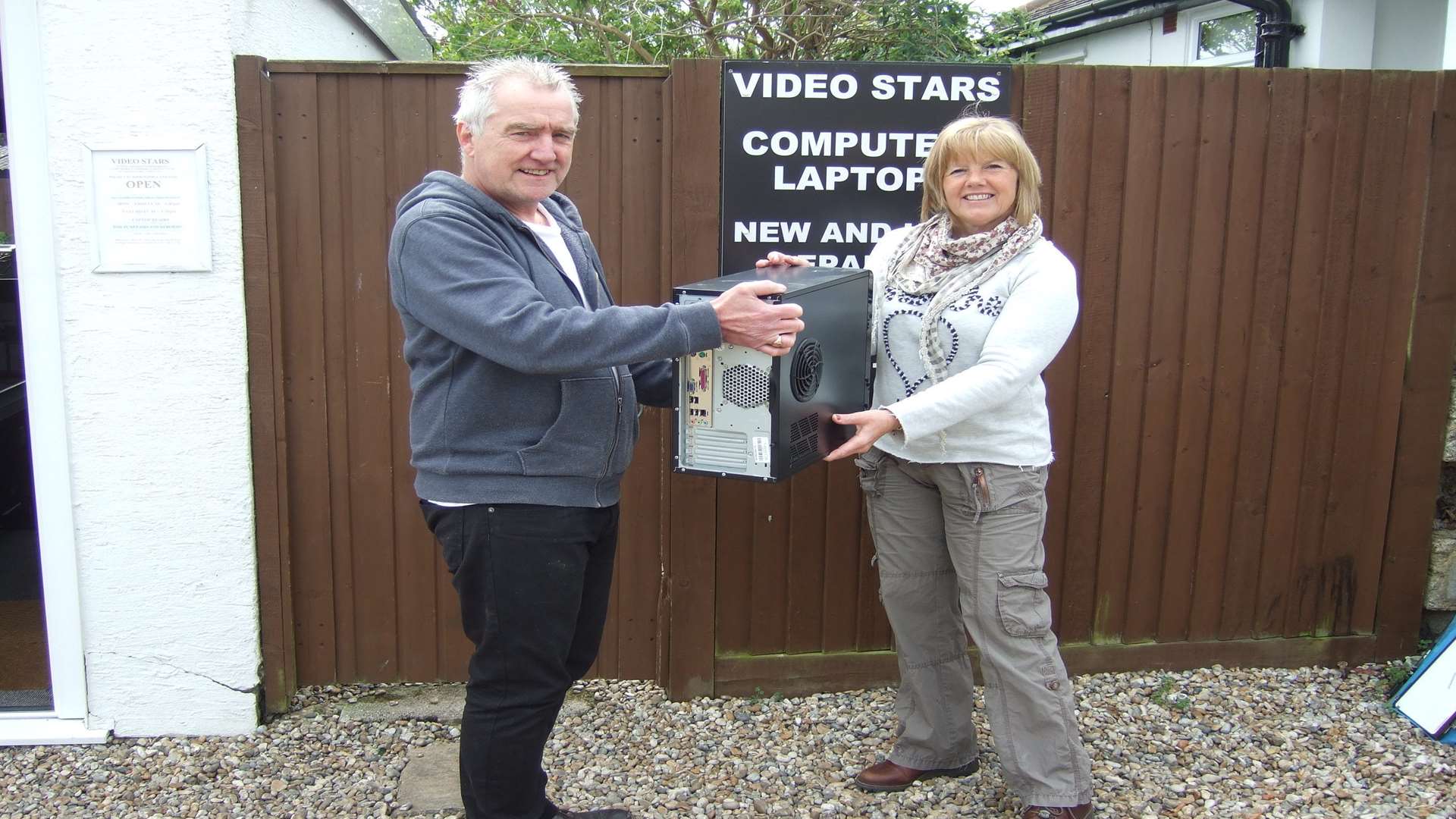 Graham McManus handing the PC over to Anne Murphy who will present it to the family.