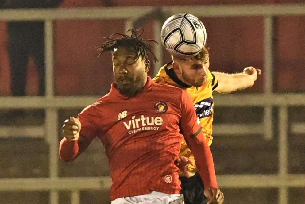 Fleet striker Dominic Poleon misses out in the air to Maidstone centre-back George Fowler. Picture: Steve Terrell