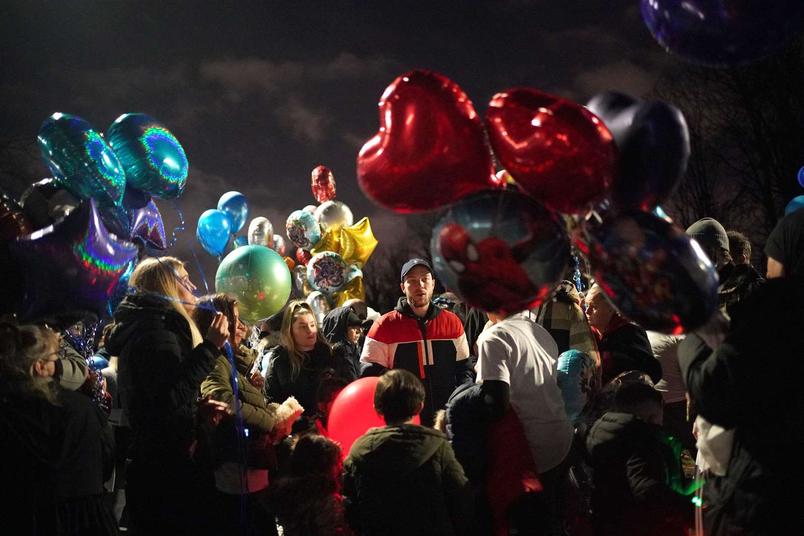 Dalton Hoath (centre) the father of brothers Kyson and Bryson, aged four, and Leyton and Logan, aged three, stands with people prior to a balloon release in Sutton in memory of his sons (Yui Mok/PA)