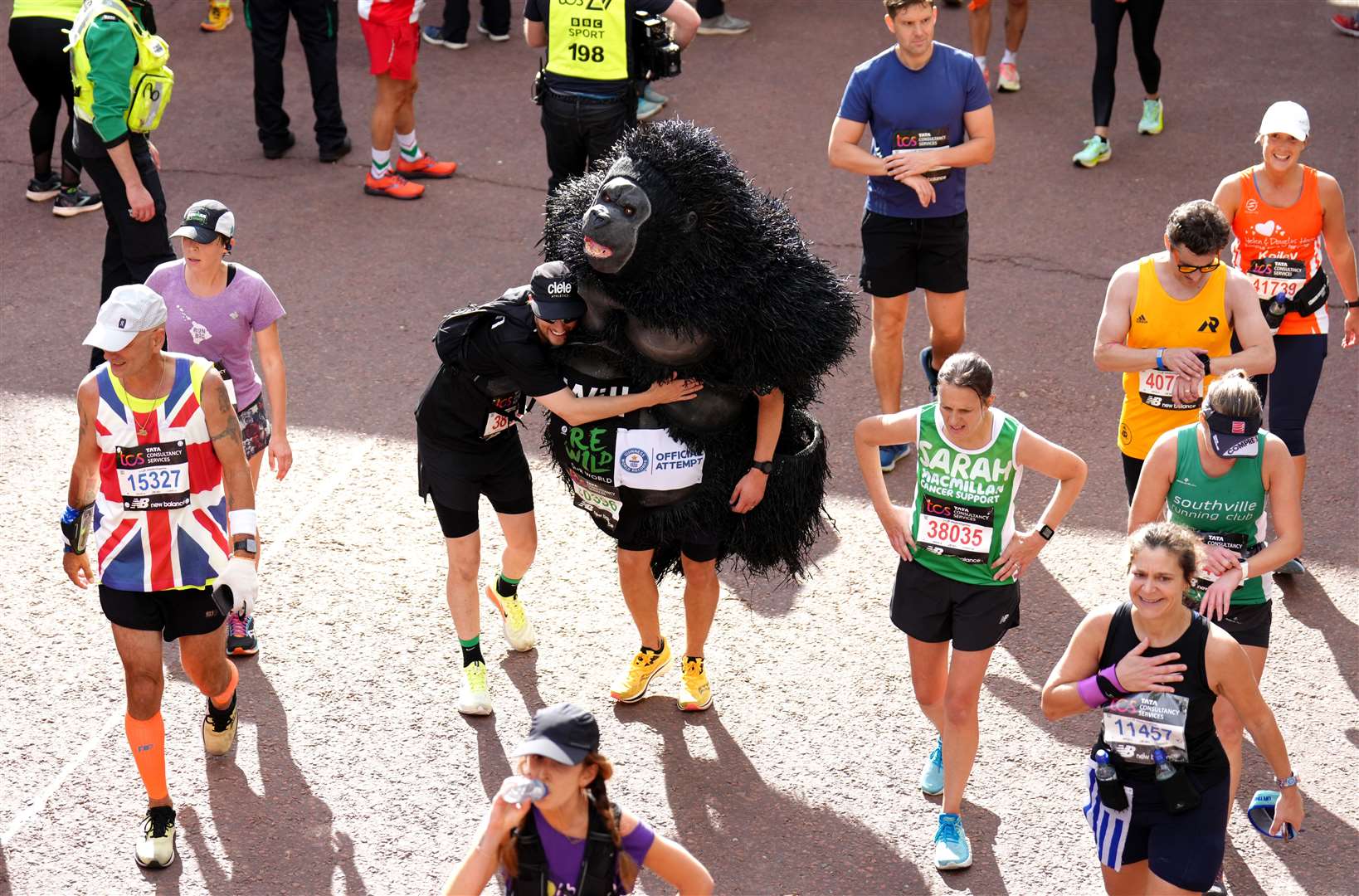 A gorilla is there to congratulate others as participants reach the finish line (John Walton/PA)