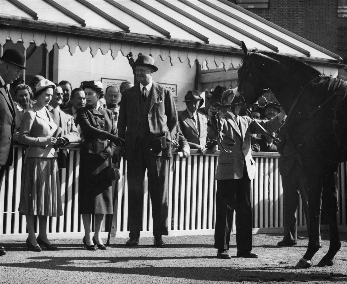 Princess Margaret listens as the Queen points to her colt Doutelle, who had just won the 2,000 Guineas at Kempton Park in 1957 (PA)