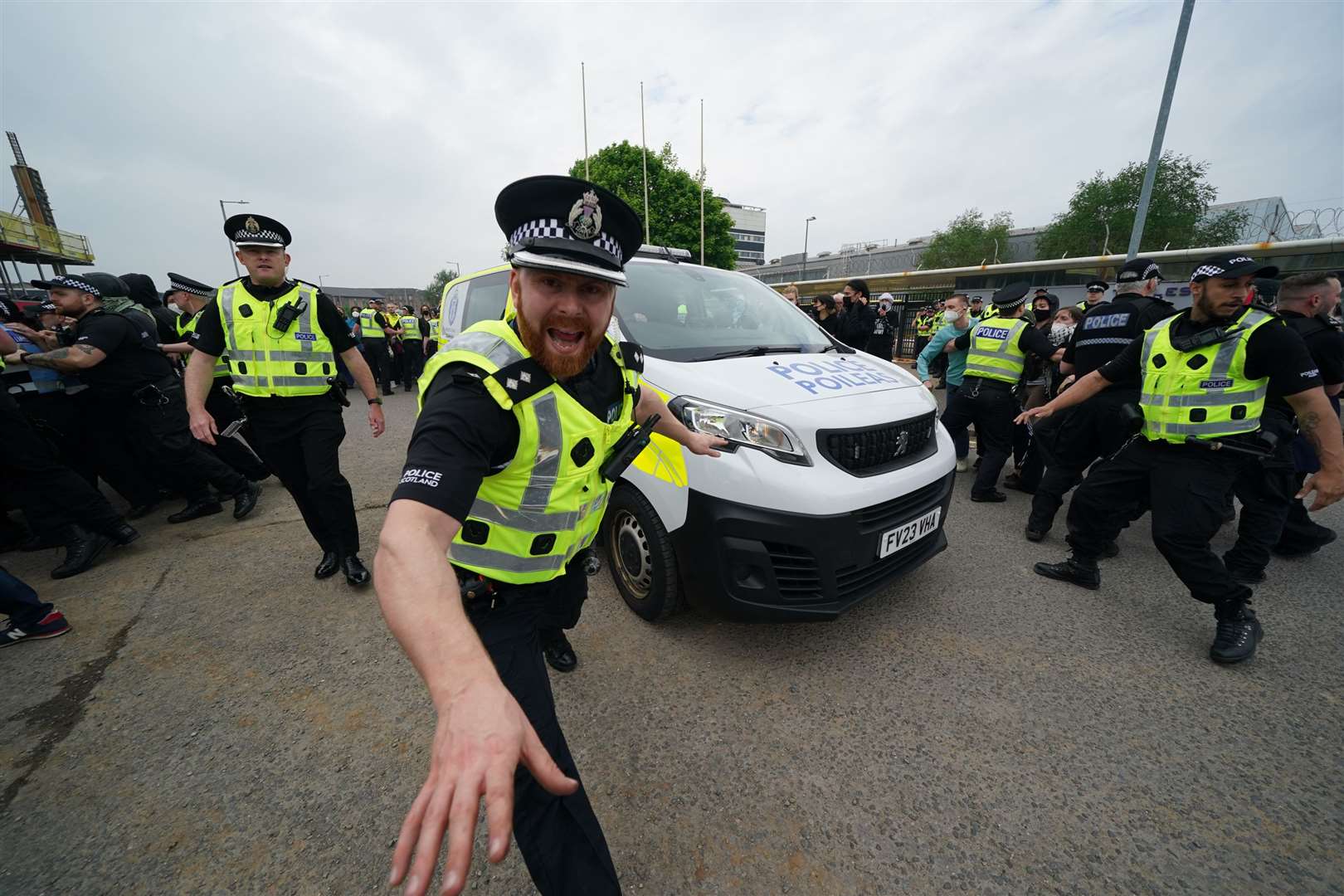 Officers clear a path for a police vehicle during a protest outside the Thales factory in Govan, Glasgow (Andrew Milligan/PA)