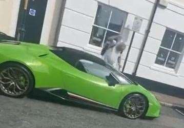 Darren Babbage raises an empty pint glass to smash down on Mat Velvick's Lamborghini. Picture: CPS South East