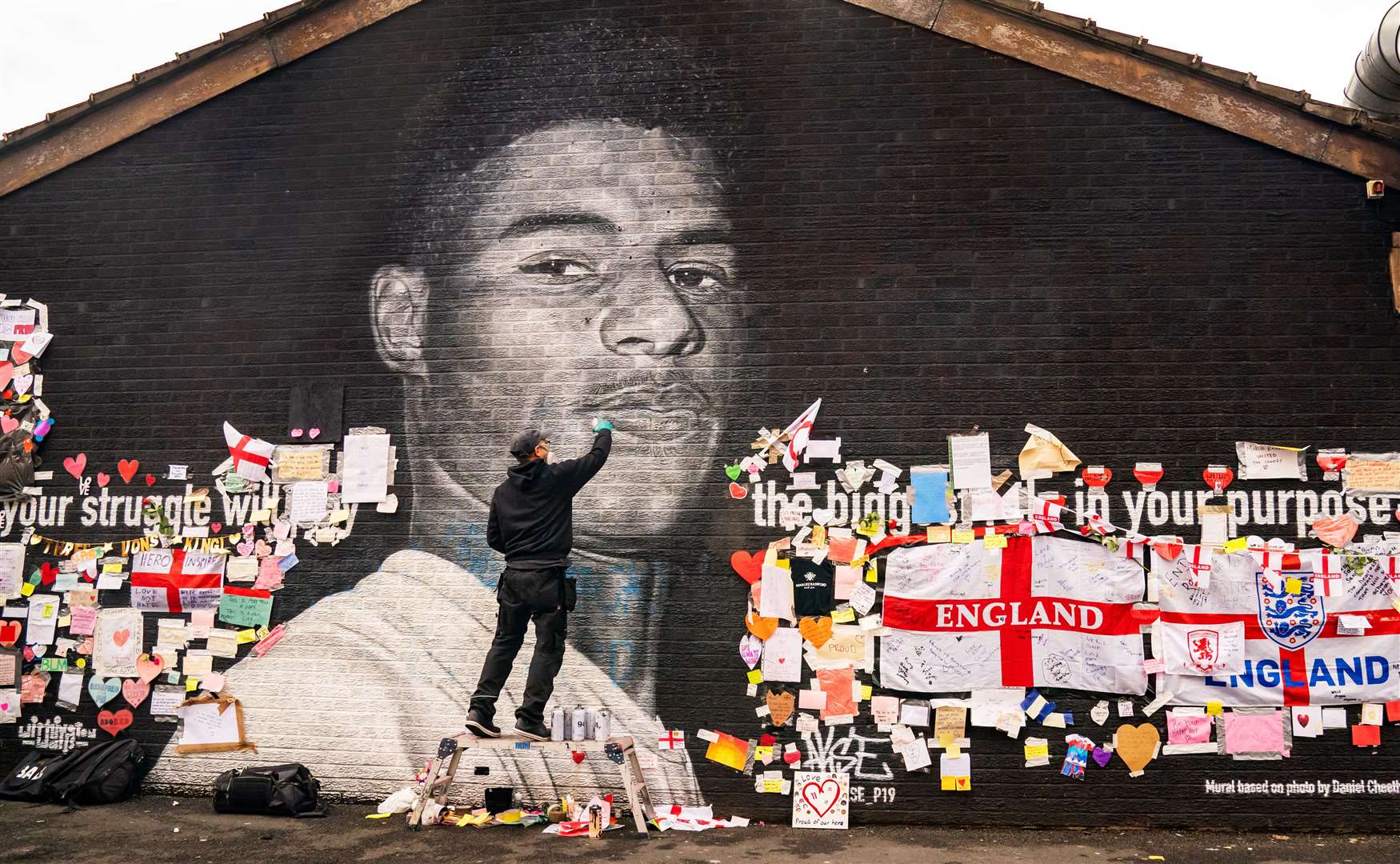 Street artist Akse P19 repairs the mural (Danny Lawson/PA)