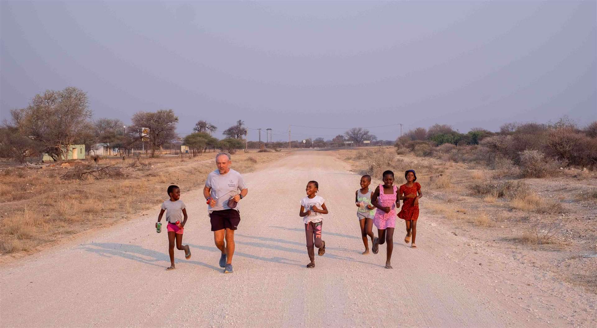 Keith Boyd runs with children in Africa (Rainbow Leaders/PA)