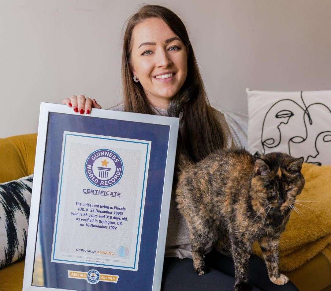 World's oldest cat Flossie, 26, with her certificate and new owner Vicki Green, 27. Picture: Cats Protection