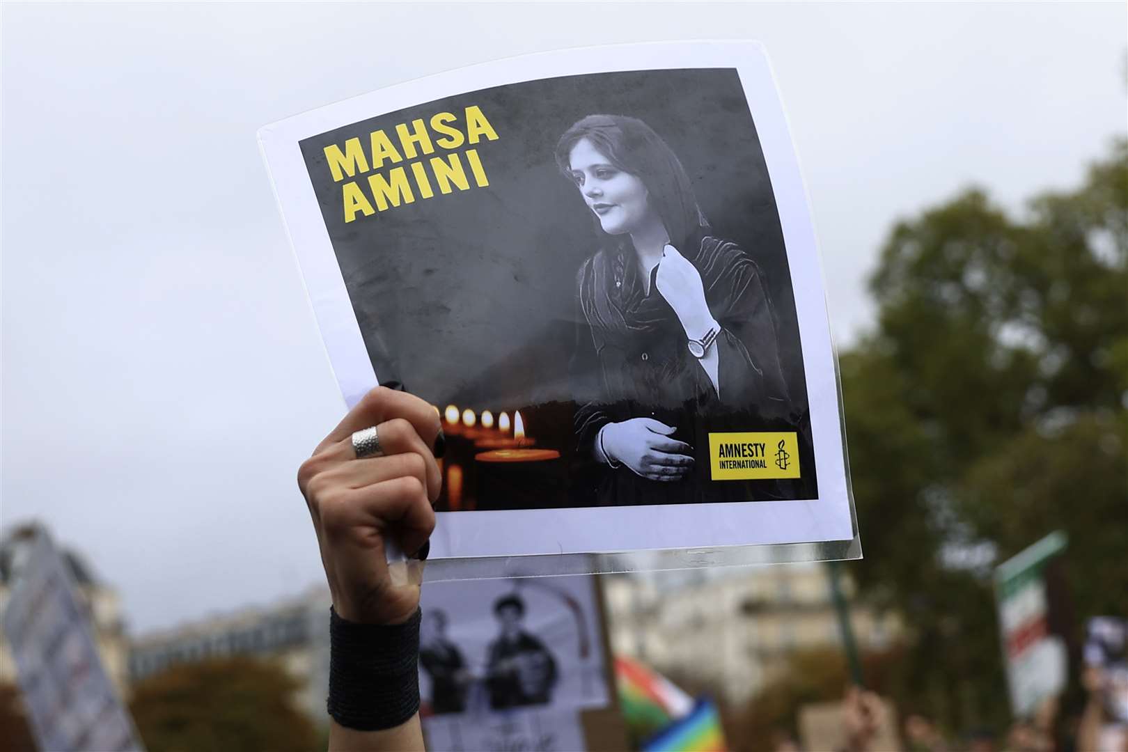 A protester in Paris shows a portrait of Mahsa Amini during a demonstration to support Iranian protesters (Aurelien Morissard/AP)