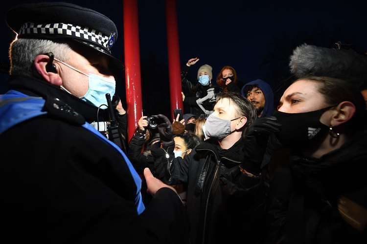 Police confront protesters at the vigil in Clapham