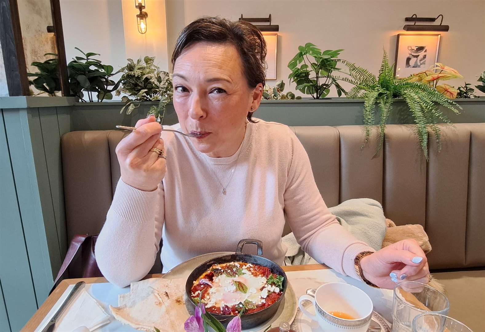 Nikki White tucks into the Shakshuka baked eggs with red peppers and tomatoes seasoned with cumin, smoked paprika, cayenne and spinach leaves with flatbread