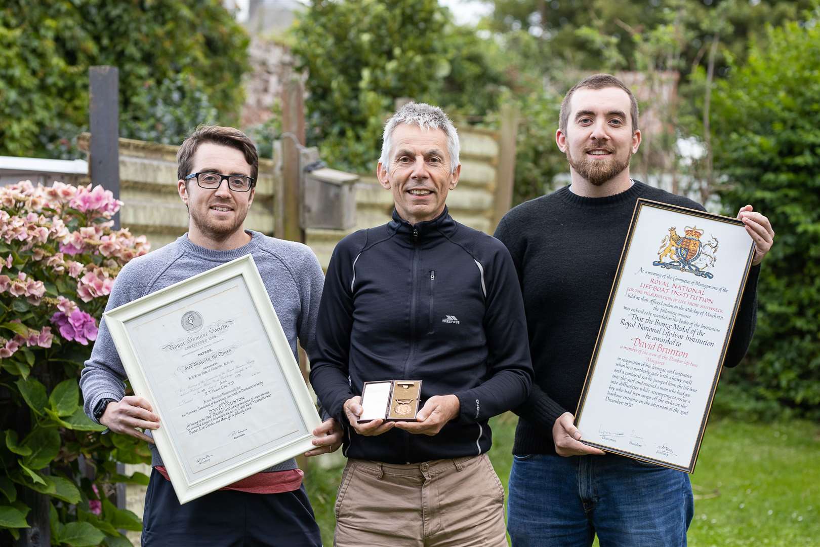 David Brunton’s son Jamie with his sons holding the bravery medal and certificates (Nick Mailer/PA)