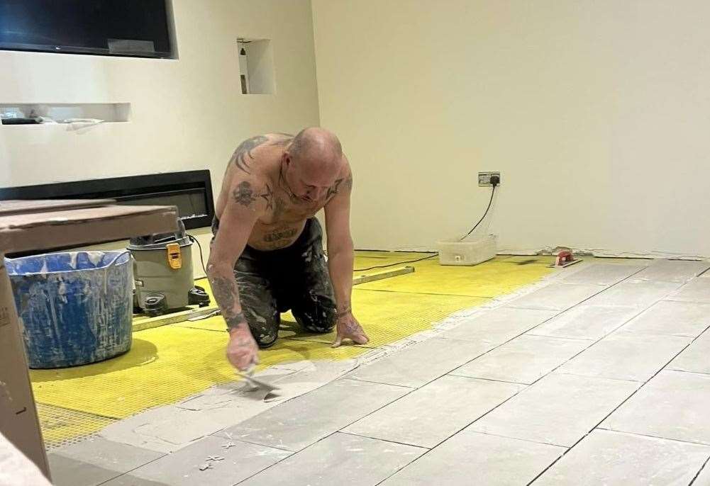 Peter Chadwick installing flooring at the family's home