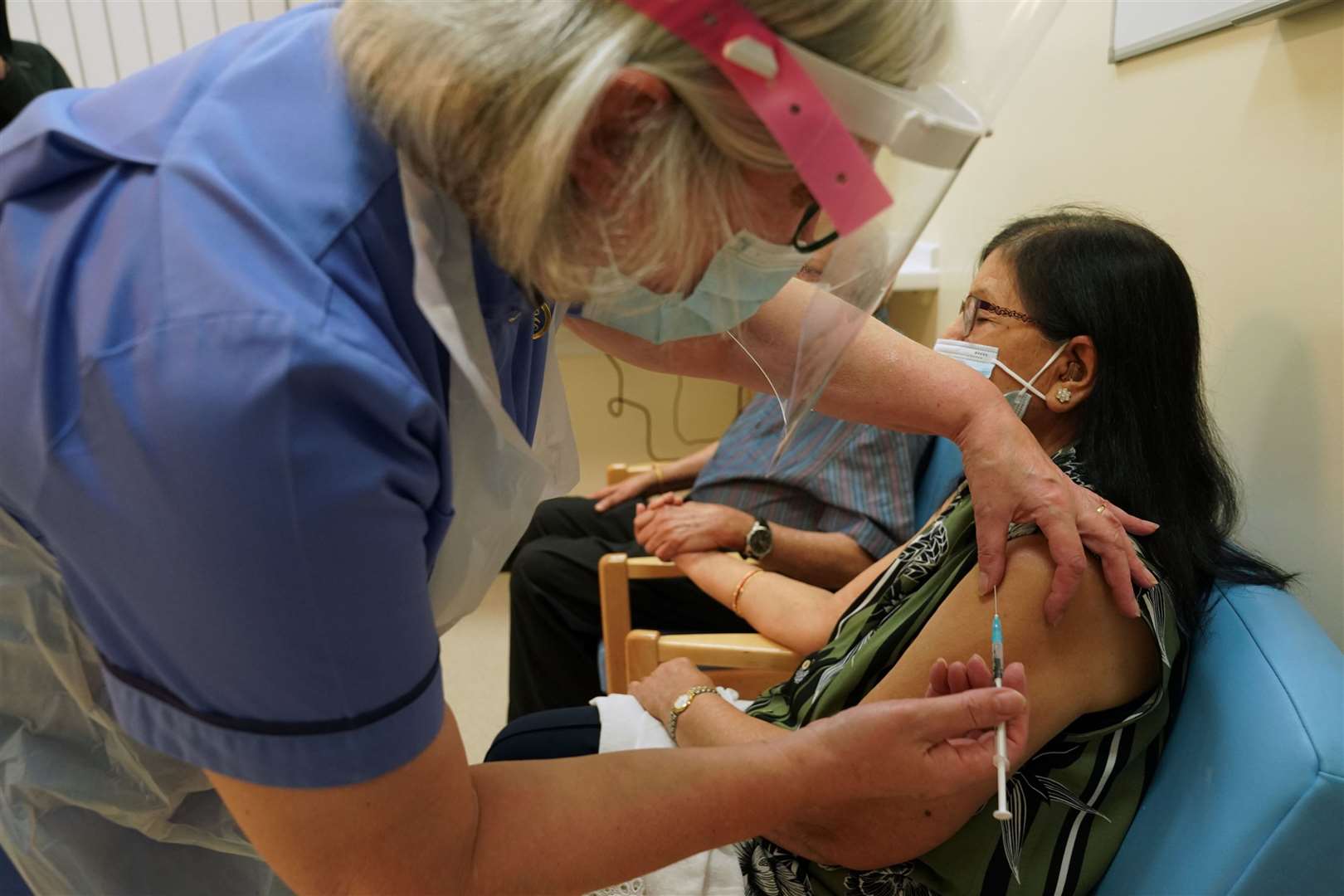 Ranjan Shukla receives the first of two Pfizer/BioNTech Covid-19 vaccine jabs, administered by retired nurse Suzanne Medows, at the Royal Victoria Infirmary in Newcastle (Owen Humphreys/PA)