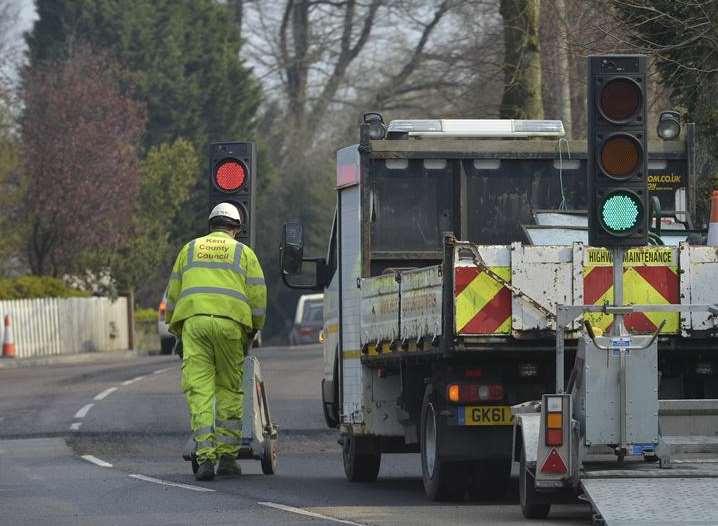 Workmen repairing potholes