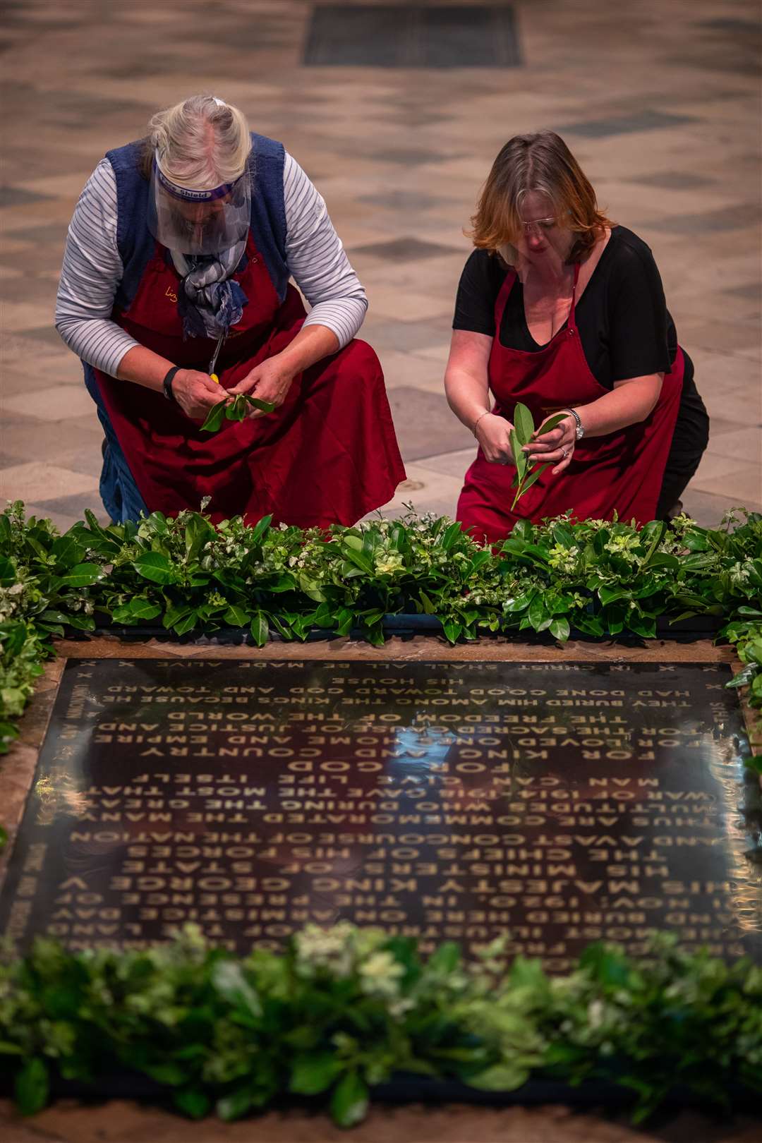 Women from the National Association of Flower Arrangers arrange laurel on the grave of the Unknown Warrior in Westminster Abbey, London (Aaron Chown/PA)