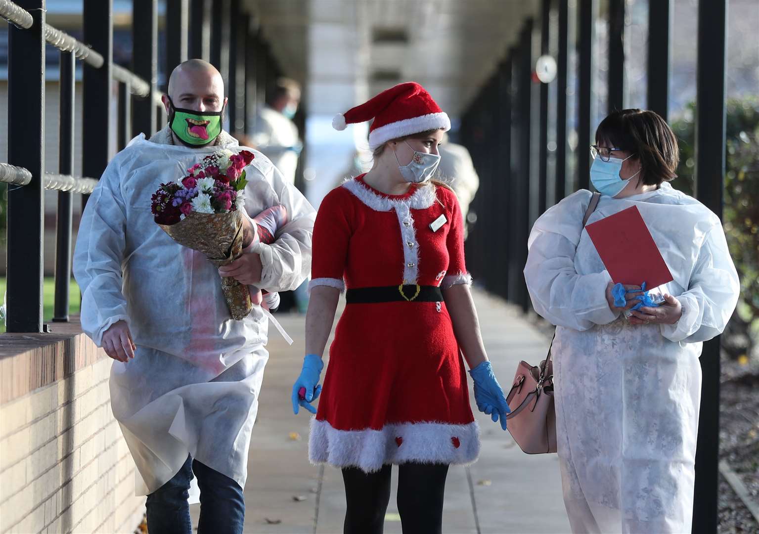 Activities co-ordinator Claire Paver (centre) walks with Mary Orme and her son Michael McKimm as they arrive for a Christmas Day visit with their mother and grandmother, Rose McKimm, at Aspen Hill Village care home in Hunslet, Leeds (Danny Lawson/PA)