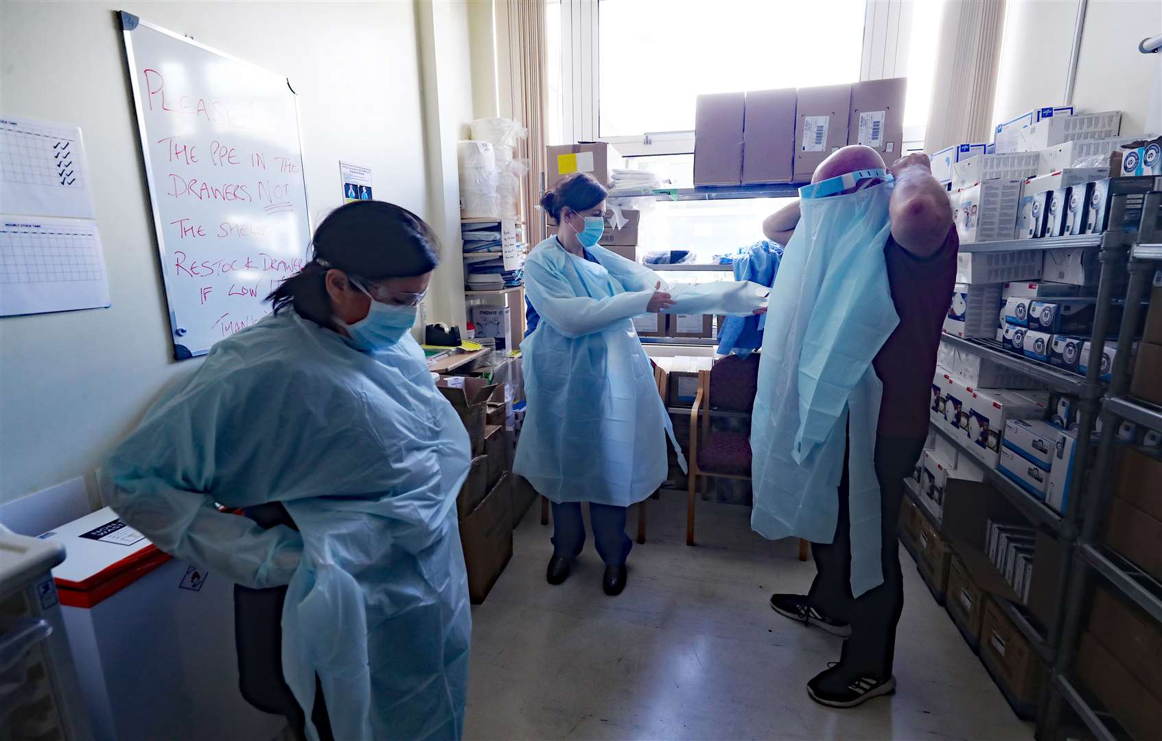 Medical staff don PPE for the intensive care ward (Niall Carson/PA)