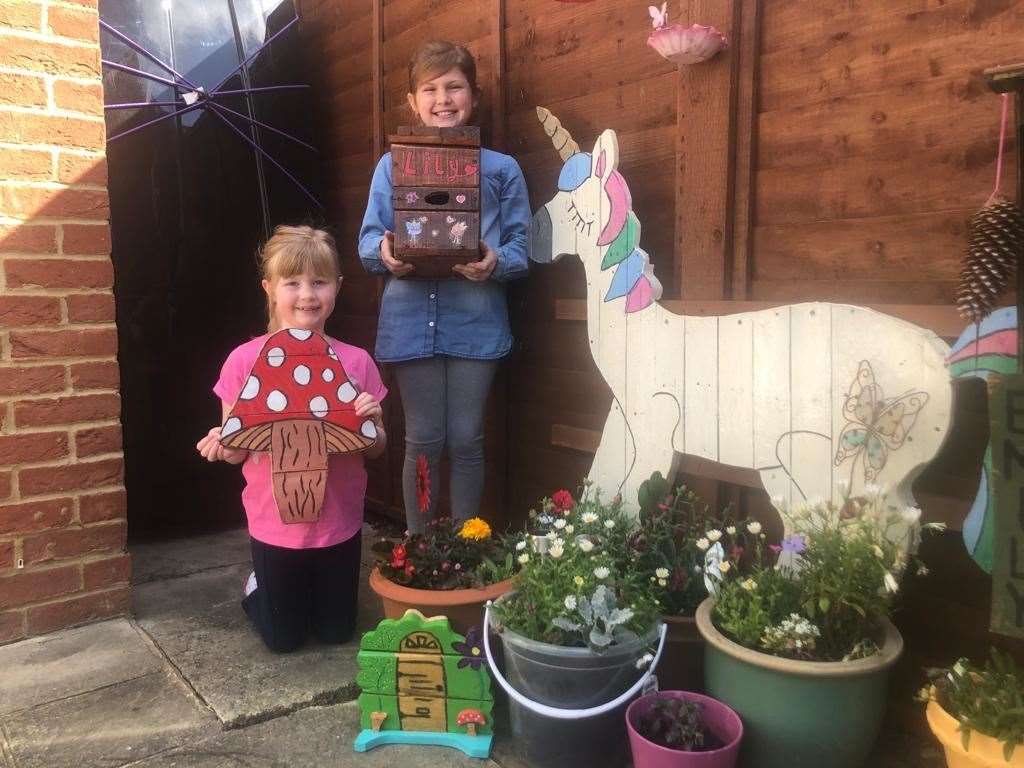 Rosie, 8 and Emily, 6 pose with their creations