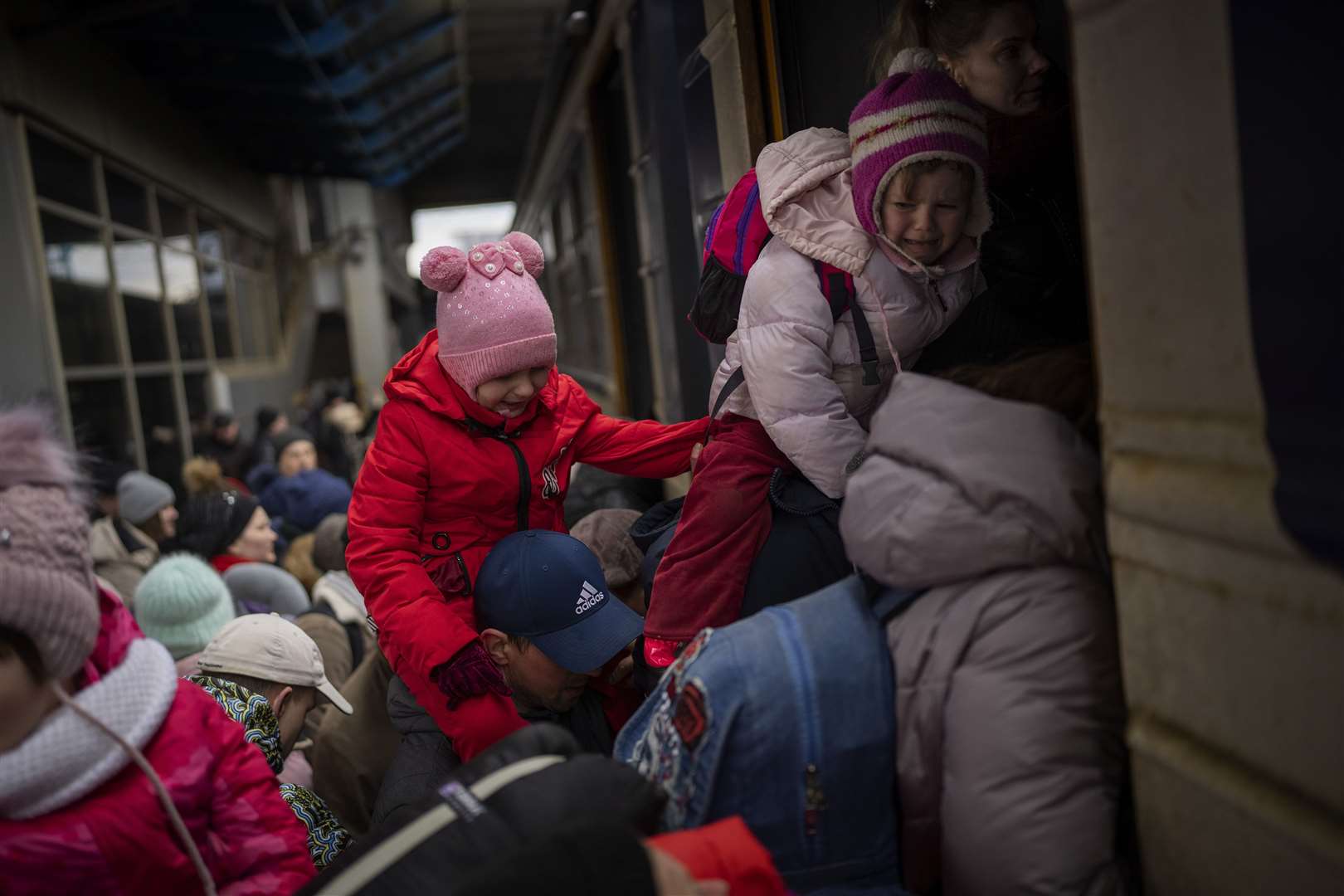 People holding their children struggle to get on a train to Lviv at Kyiv station, Ukraine (Emilio Morenatti/AP)