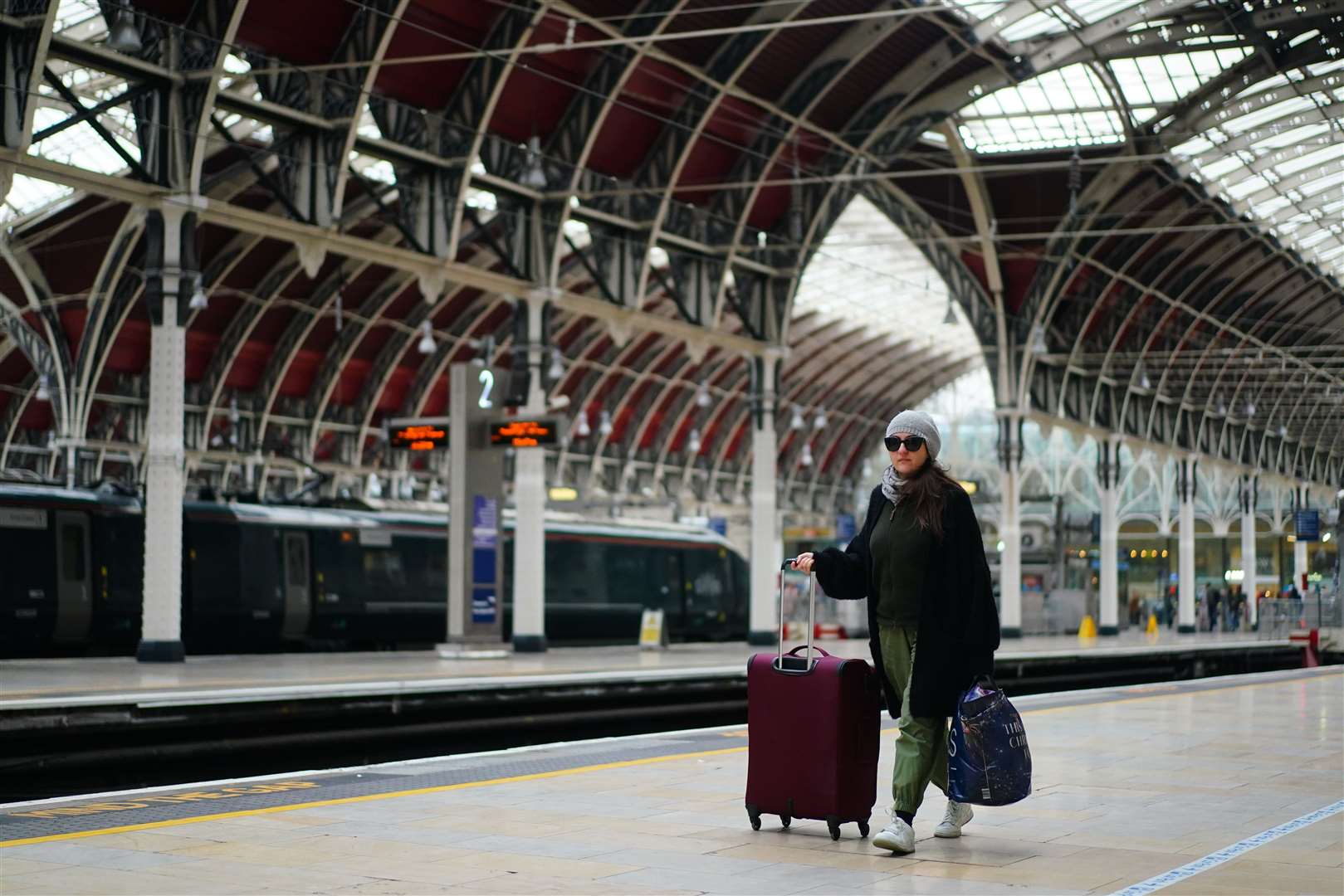 A woman with suitcases at an empty Paddington station in London during a strike by members of the RMT in a long-running dispute over jobs and pensions (Victoria Jones/PA)