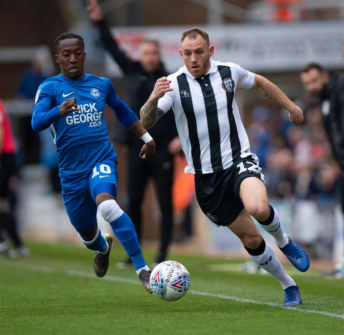 Gillingham defender Barry Fuller gets away from Peterborough's Siriki Dembele Picture: Ady Kerry