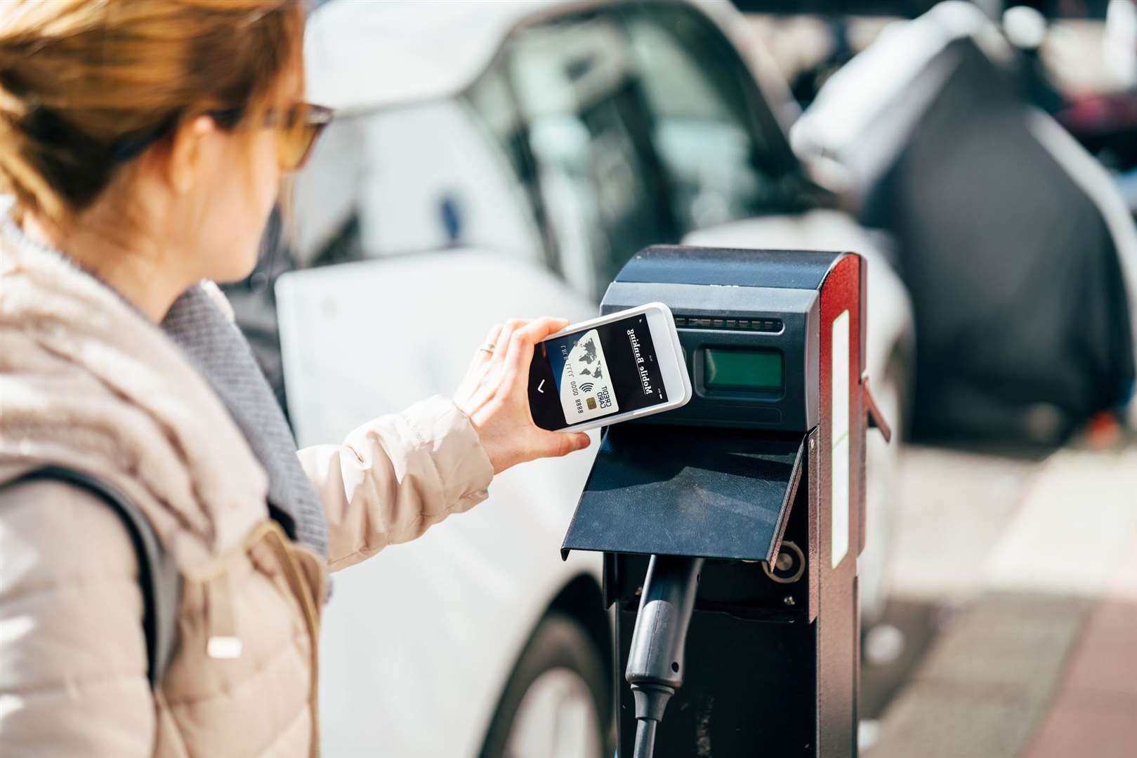 Customer paying with digital wallet at electric vehicle charging station in UK,London.
