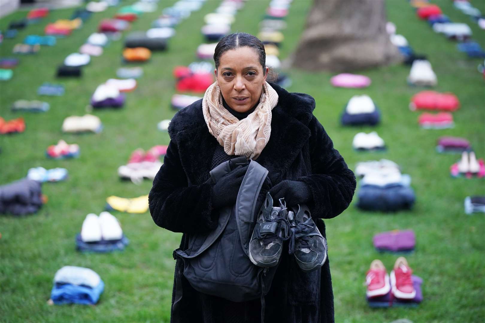 Yemi Hughes, holding clothes her son Andre Aderemi, 19, was wearing when he was stabbed to death in Croydon in 2016 (Yui Mok/PA)