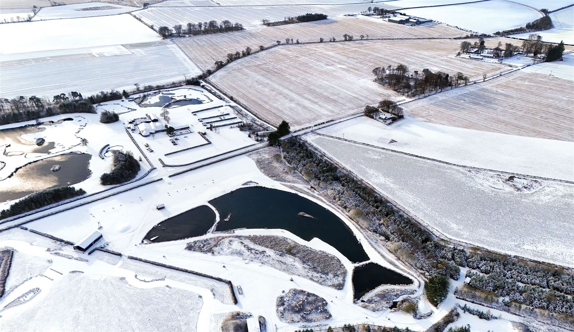 The man-made fish-shaped Muckle Troot Loch near Inverurie, Aberdeenshire, is surrounded by snow and ice as temperatures fall in November (Jane Barlow/PA)