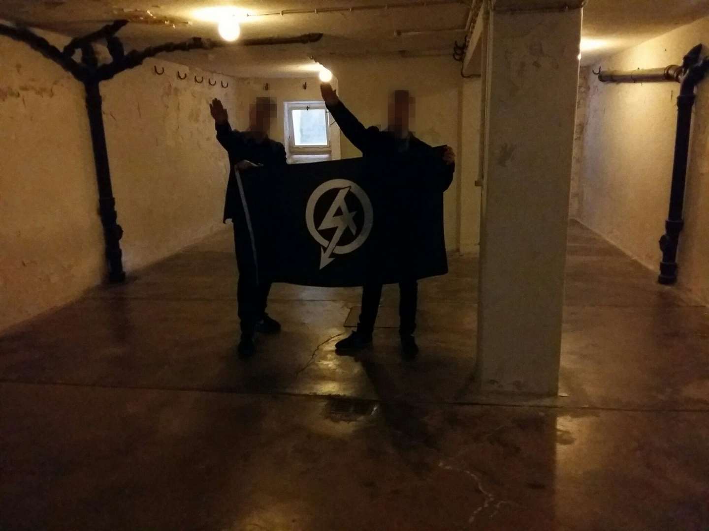 Mark Jones and another man giving a Nazi-style salute in the execution room of what was Buchenwald death camp (West Midlands Police/PA)