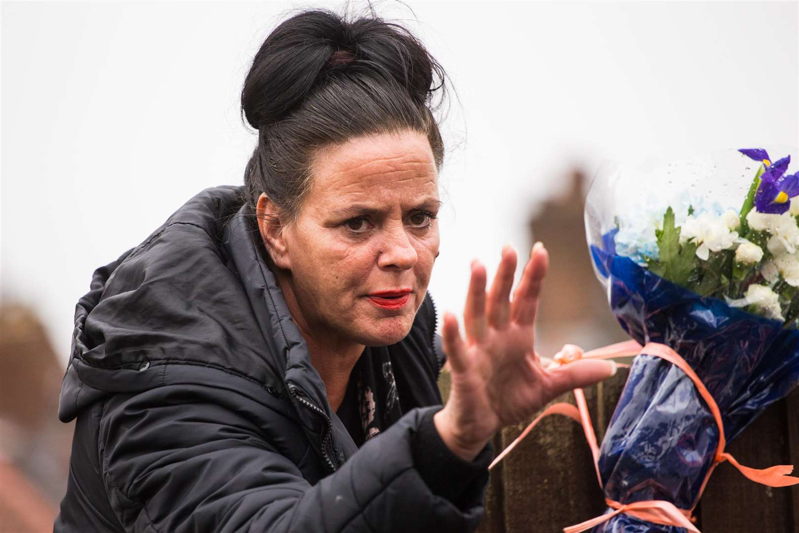 A woman arrived in Hither Green to stop the flowers being removed. Pictures: SWNS (1454728)