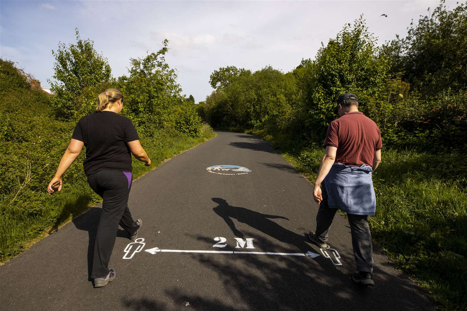 People walking past a two metre social-distancing sign (Liam McBurney/PA)