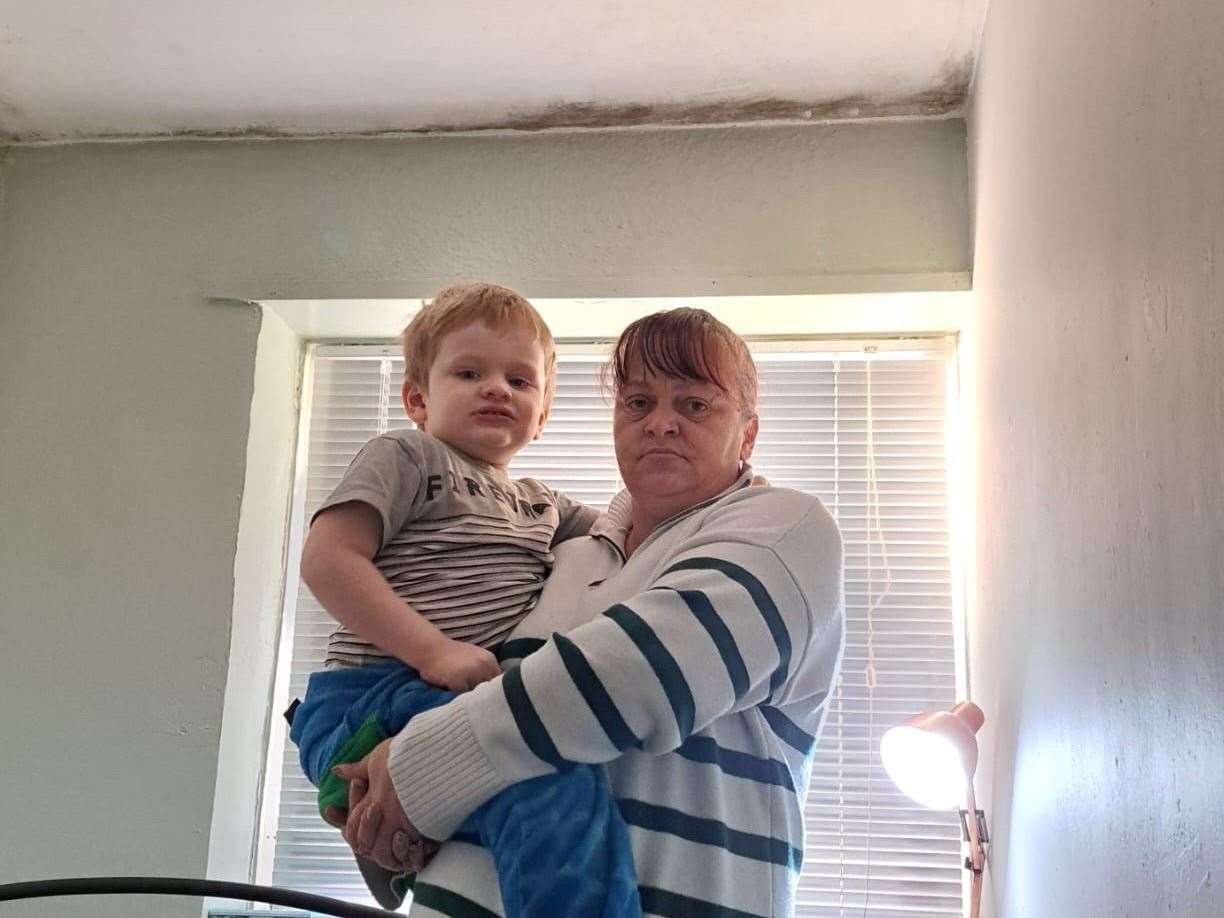 Vicky Norman and her grandson, Leland, by the mould in their house, Murston