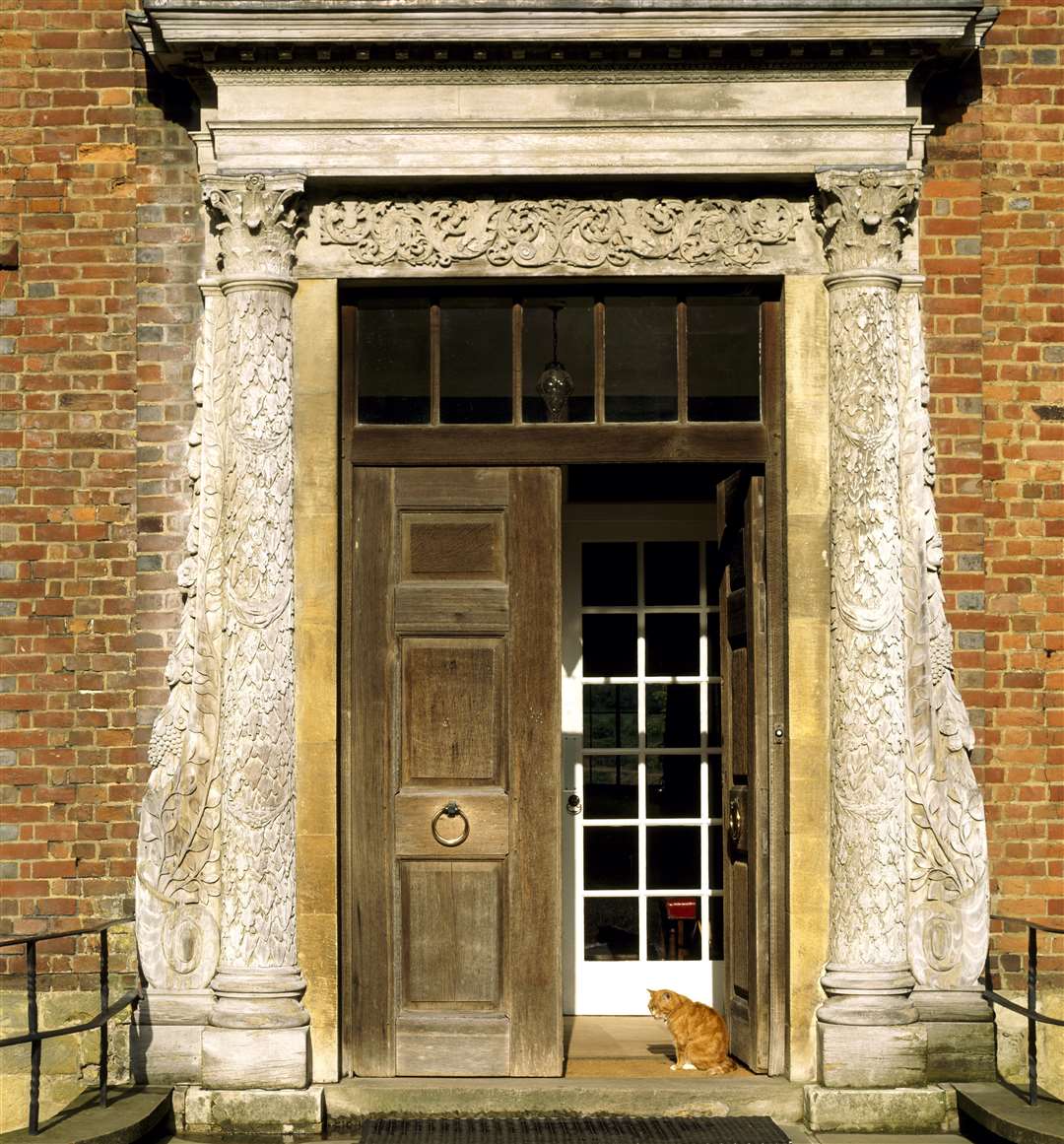 The partly open front door at Chartwell, the home of Sir Winston Churchill, with Jock the cat sitting in the sunshine Picture: National Trust