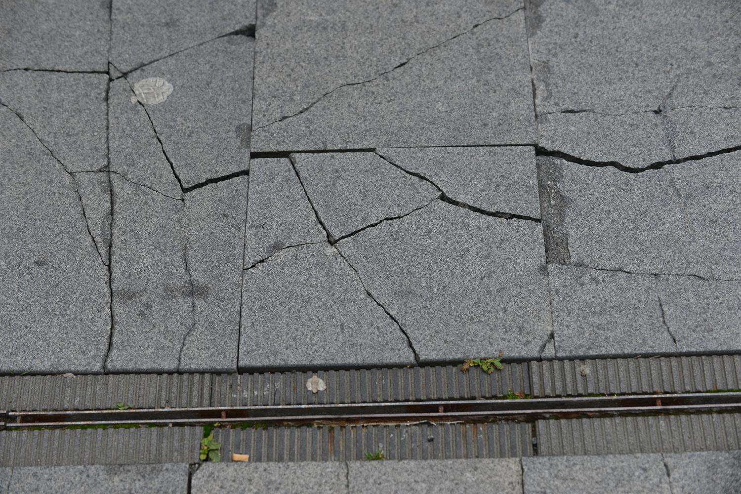 Cracked paving slabs either side of The Flume