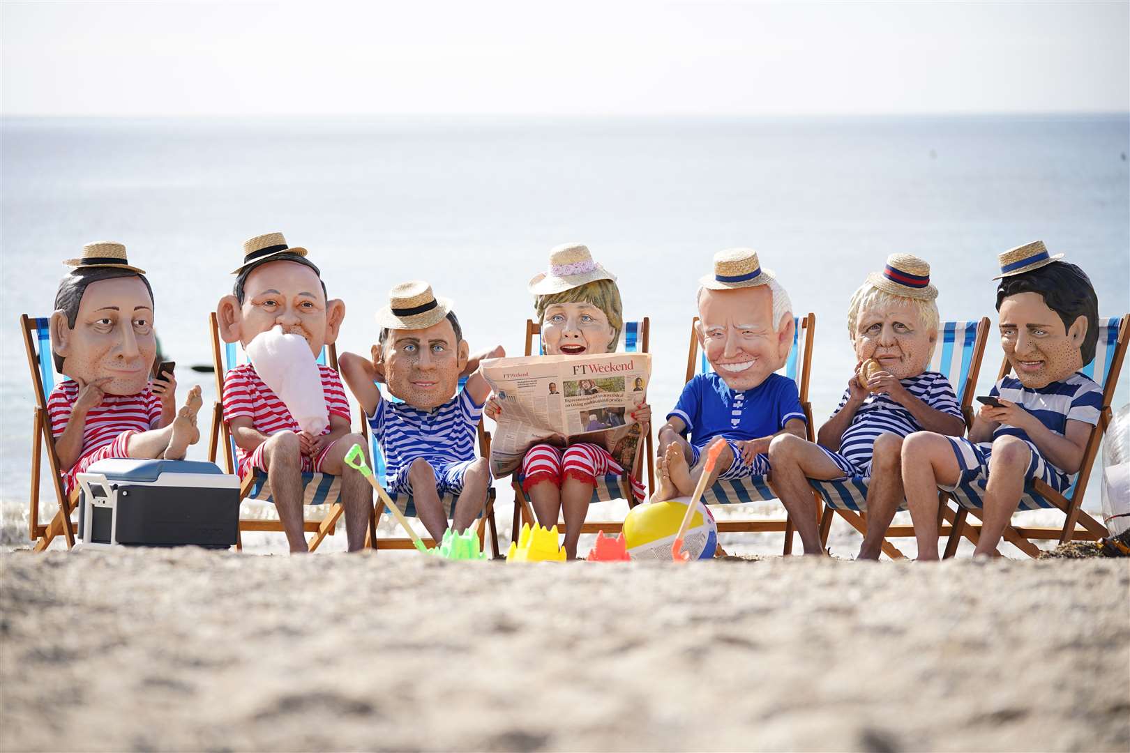 Oxfam campaigners pose as G7 leaders on Swanpool Beach near Falmouth, Cornwall. The charity is calling on the G7 countries to commit to cutting emissions further and faster (Aaron Chown/PA)