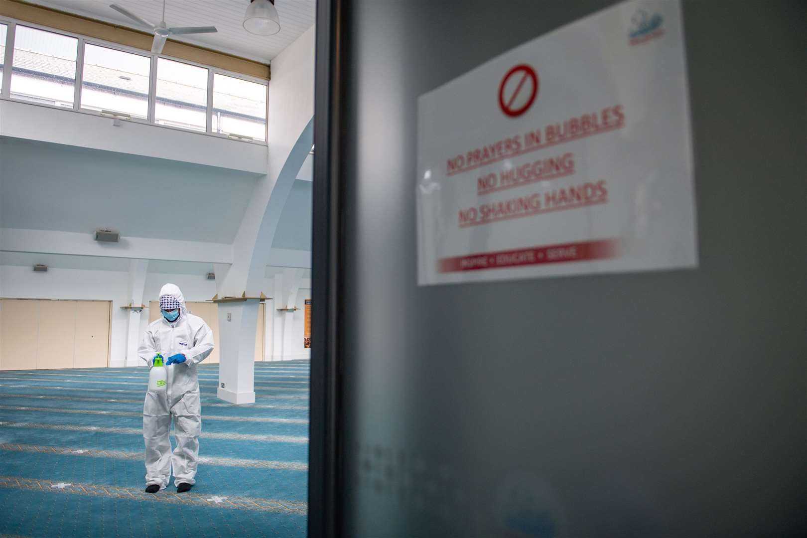 A staff member at Green Lane Mosque in Birmingham disinfects prayer rooms, ahead of Eid al-Fitr (Jacob King/PA)