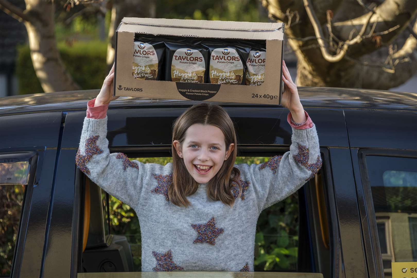 Grace, from Edinburgh, with her year’s supply of haggis crisps (Mike Wilkinson/Taylors Snacks/PA)