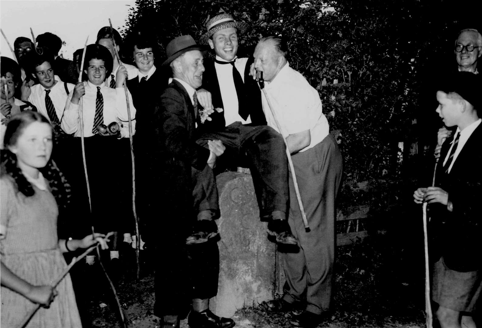 A boy is 'bumped' during a Beating the City Bounds ceremony in Canterbury in September 1955, watched by pupils from the Girls' Technical School