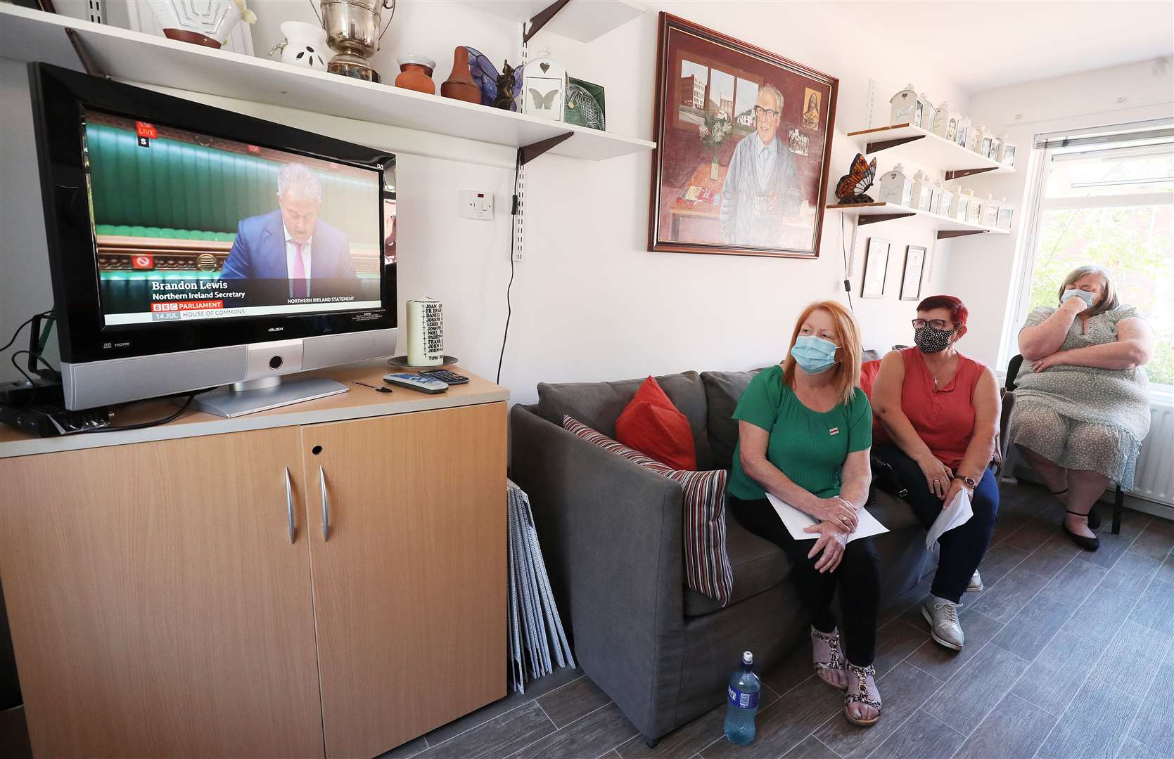 Family members of Ballymurphy massacre victims (left to right) Eileen McKeown, daughter of Joseph Corr, Mary Corr, daughter in law of Joseph Corr, and Irene Connolly, daughter of Joan Connolly at Springhill Community House in Belfast, watching Secretary of State for Northern Ireland Brandon Lewis in the House of Commons (Brian Lawless/PA)