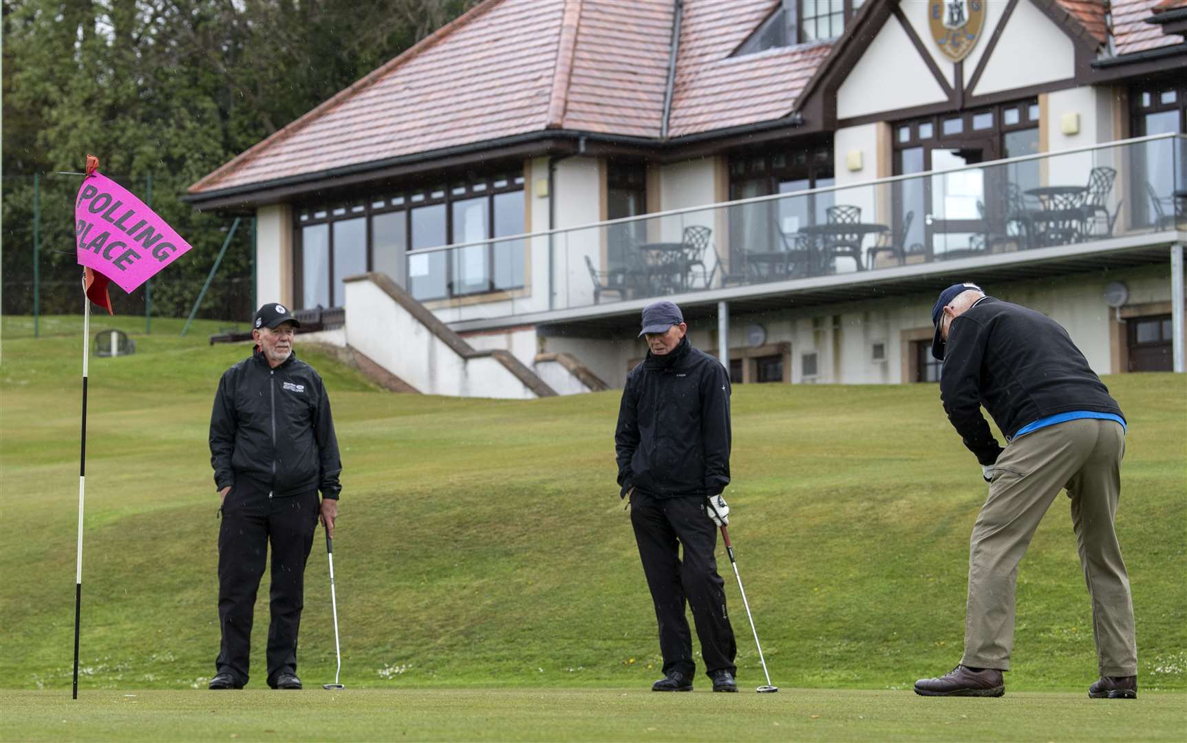 Golfers practise their putting as they arrive to cast their votes in the Scottish Parliamentary election at the polling station in the club house at the Merchants of Edinburgh Golf Club (Lesley Martin/PA)