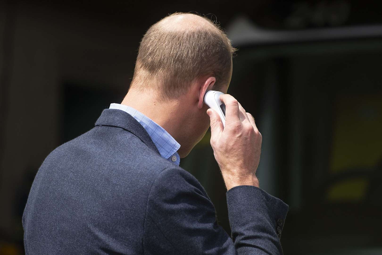 The Duke of Cambridge places a thermometer in his ear to check his temperature as he arrives at the ambulance station (Victoria Jones/PA)