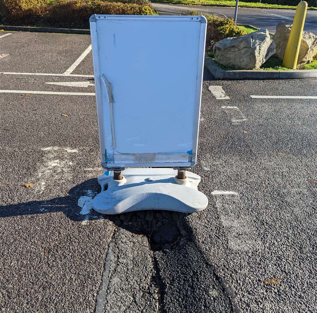 A disused sign has been used to cover the hole