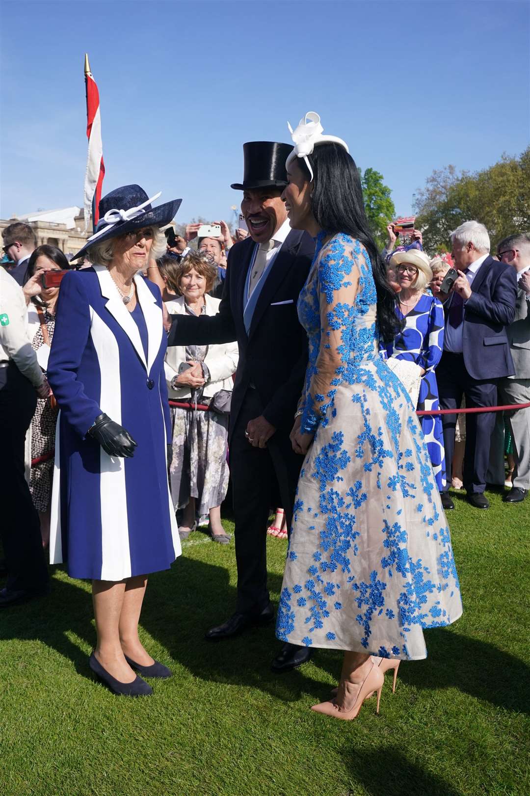 The Queen Consort speaks to Lionel Richie and Lisa Parigi during the garden party at Buckingham Palace (Yui Mok/PA)